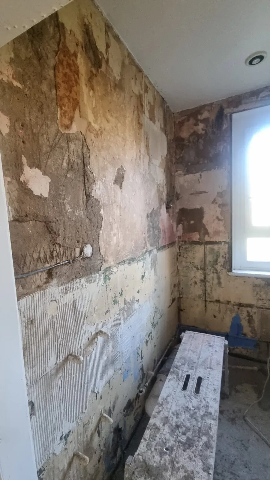 Bathroom walls stripped back to bare brick and old plaster