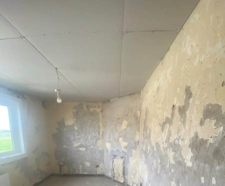 Bedroom walls stripped back, old plaster peeling away