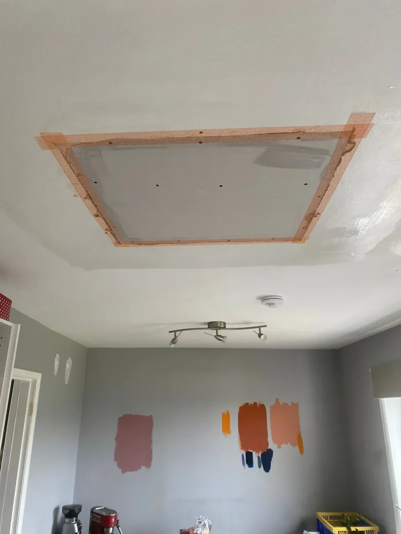 Ceiling with a new plasterboard patch fitted and taped