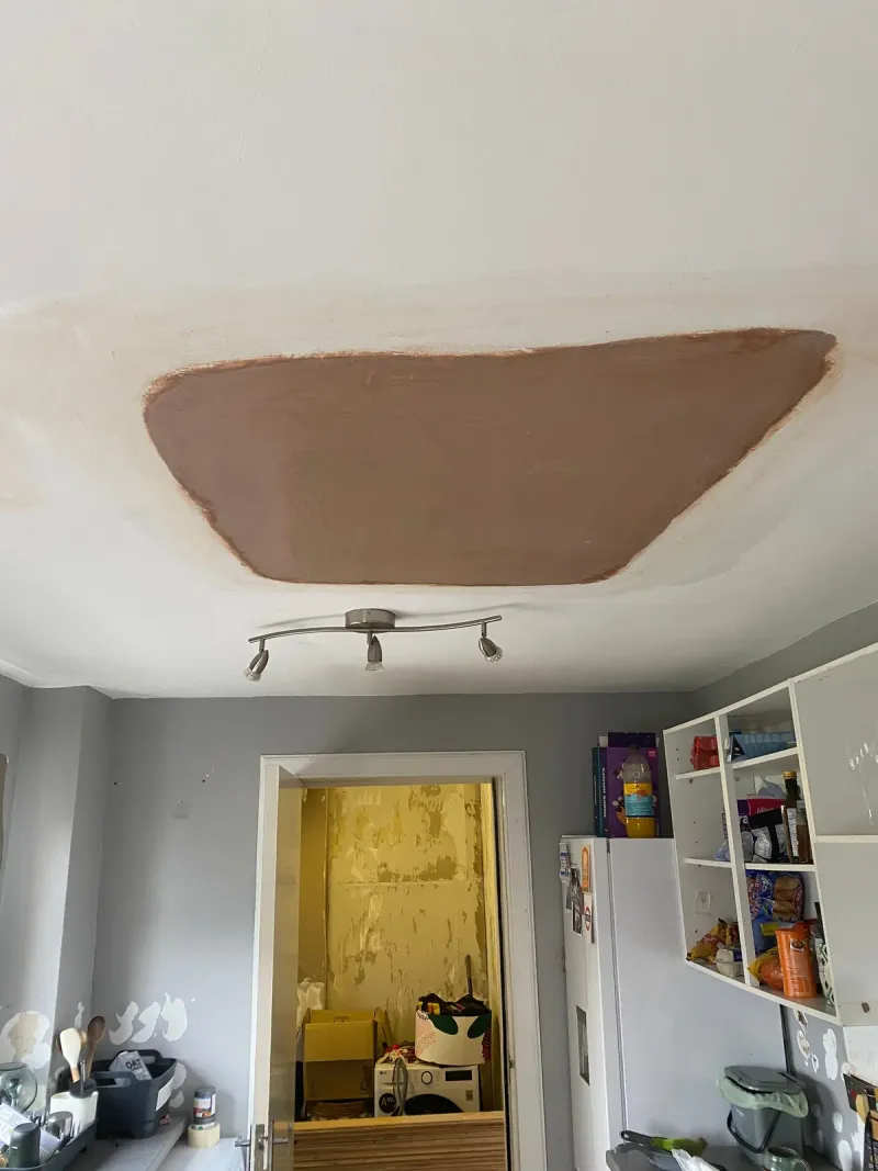 Second ceiling with a plastered patch repair ready for painting