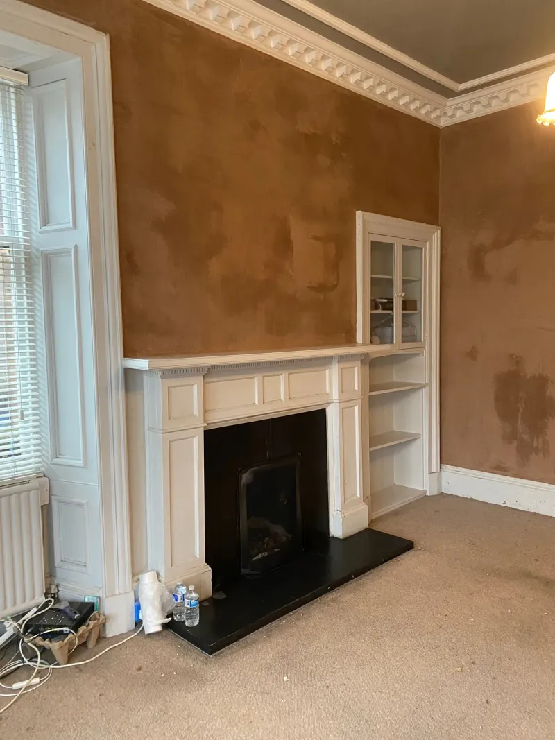 Fireplace wall and alcove in a period living room, freshly plastered